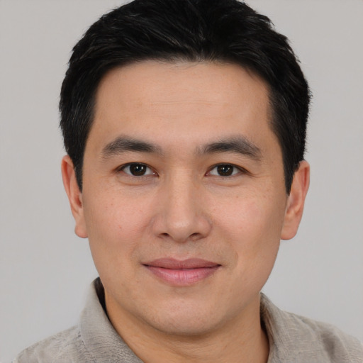 Joyful asian young-adult male with short  black hair and brown eyes