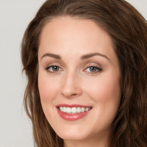 Joyful white young-adult female with long  brown hair and green eyes