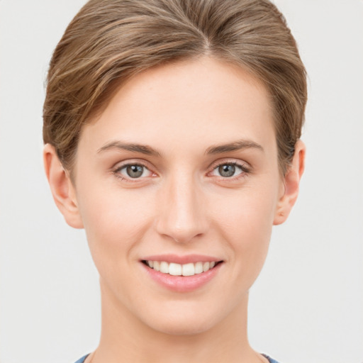 Joyful white young-adult female with short  brown hair and grey eyes