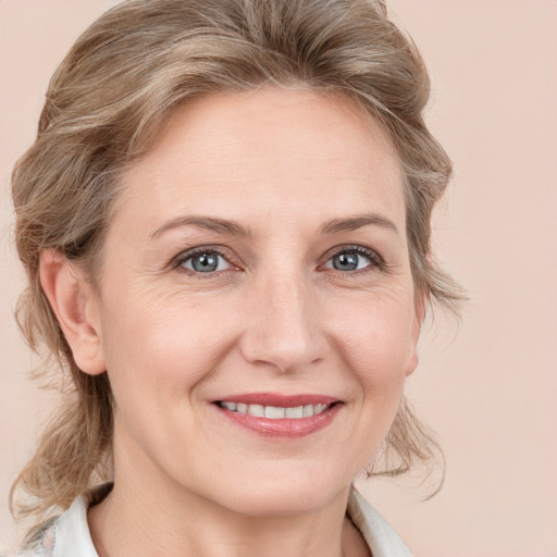 Joyful white adult female with medium  brown hair and grey eyes