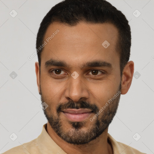 Joyful black young-adult male with short  black hair and brown eyes