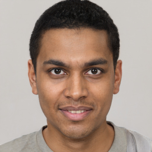 Joyful black young-adult male with short  black hair and brown eyes