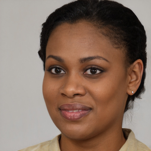 Joyful black young-adult female with short  black hair and brown eyes