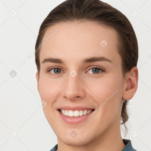 Joyful white young-adult female with short  brown hair and grey eyes