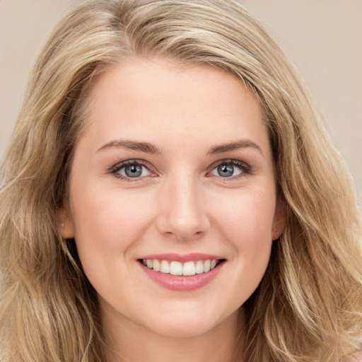 Joyful white young-adult female with long  brown hair and blue eyes