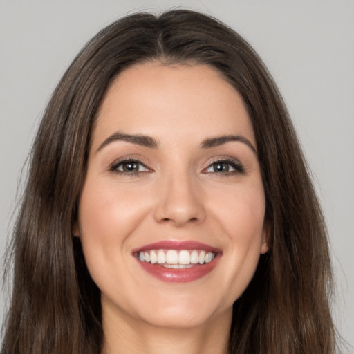 Joyful white young-adult female with long  brown hair and brown eyes