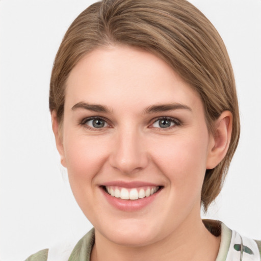 Joyful white young-adult female with medium  brown hair and green eyes