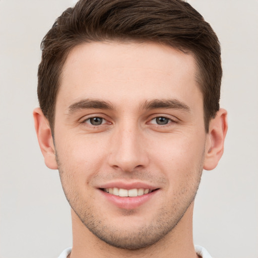 Joyful white young-adult male with short  brown hair and grey eyes