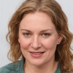 Joyful white adult female with medium  brown hair and blue eyes