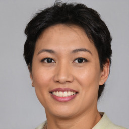 Joyful asian young-adult female with short  brown hair and brown eyes