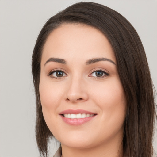 Joyful white young-adult female with long  brown hair and brown eyes