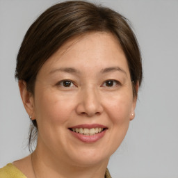 Joyful white adult female with medium  brown hair and brown eyes