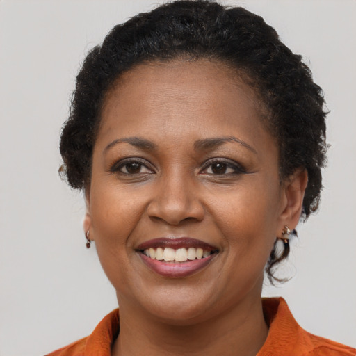 Joyful black young-adult female with short  brown hair and brown eyes