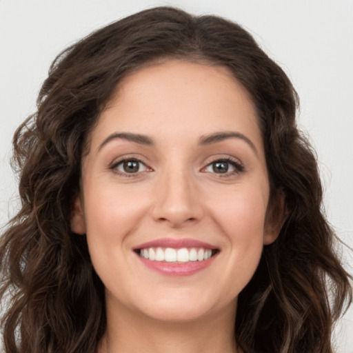 Joyful white young-adult female with long  brown hair and brown eyes