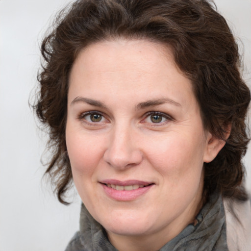Joyful white adult female with medium  brown hair and green eyes