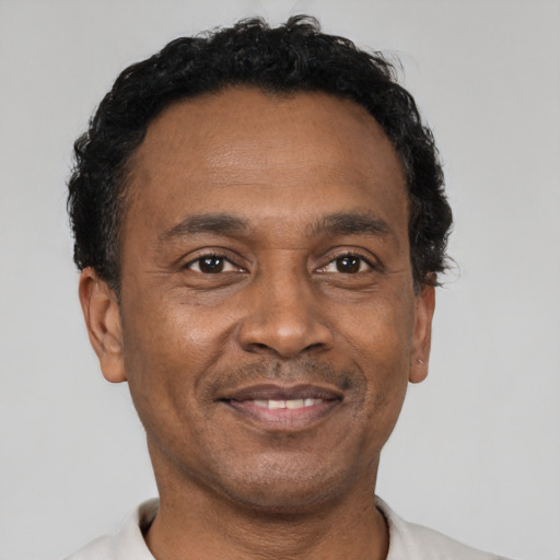 Joyful black adult male with short  black hair and brown eyes