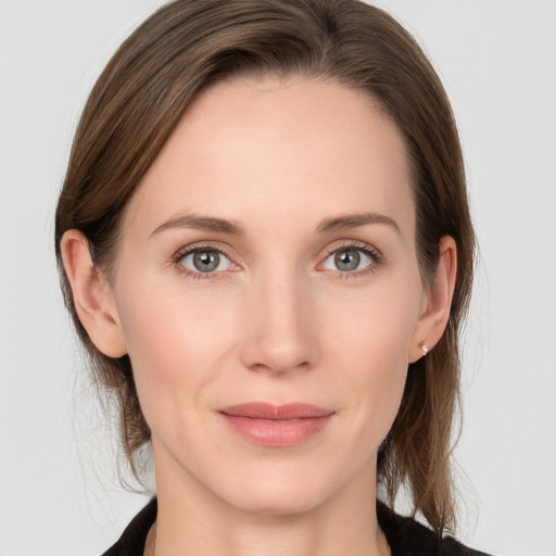 Joyful white young-adult female with medium  brown hair and grey eyes