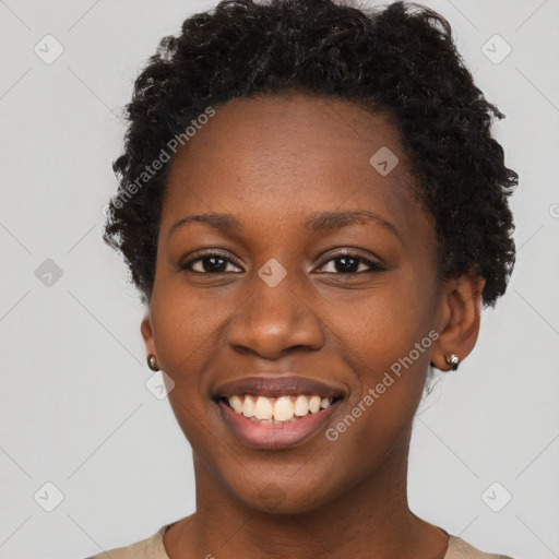 Joyful black young-adult female with short  black hair and brown eyes