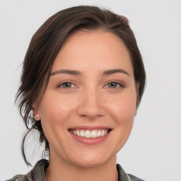 Joyful white young-adult female with medium  brown hair and grey eyes