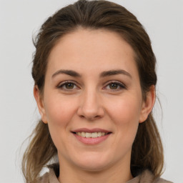 Joyful white young-adult female with medium  brown hair and grey eyes