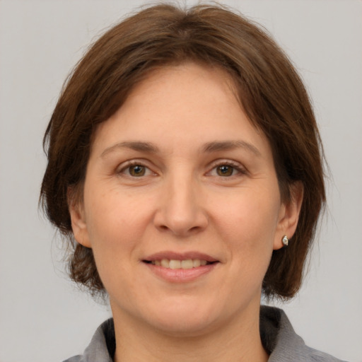 Joyful white adult female with medium  brown hair and grey eyes