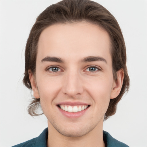 Joyful white young-adult male with medium  brown hair and grey eyes