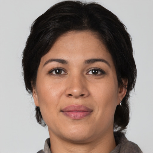 Joyful latino adult female with medium  brown hair and brown eyes