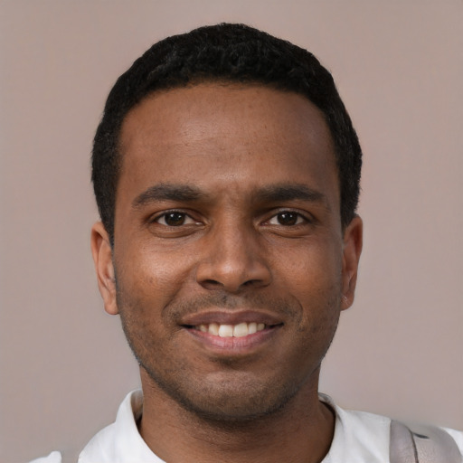 Joyful black young-adult male with short  black hair and brown eyes