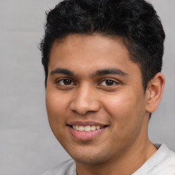 Joyful latino young-adult male with short  brown hair and brown eyes