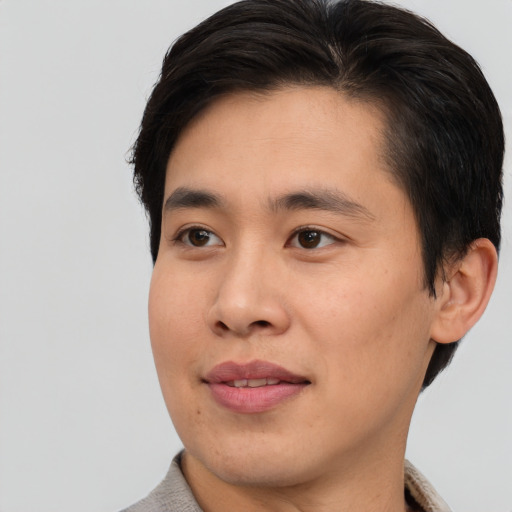 Joyful asian young-adult male with short  brown hair and brown eyes