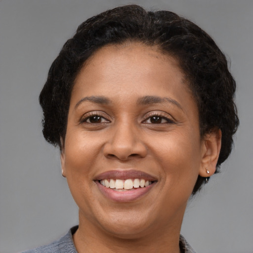 Joyful black young-adult female with short  brown hair and brown eyes