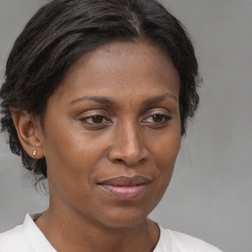 Joyful black adult female with medium  brown hair and brown eyes