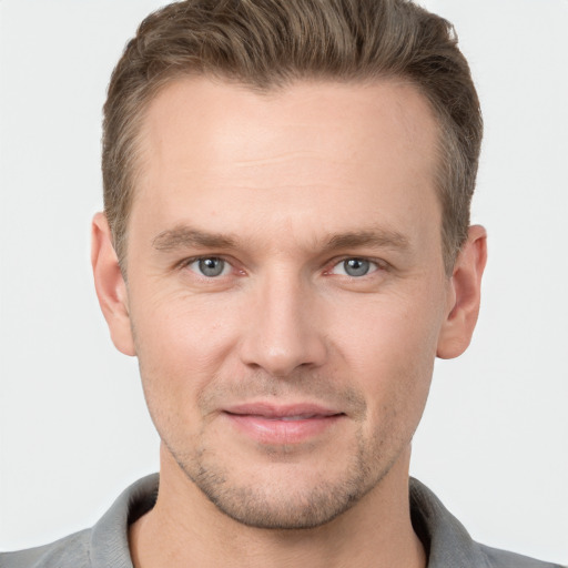 Joyful white young-adult male with short  brown hair and grey eyes