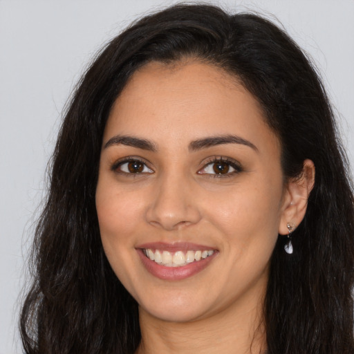 Joyful latino young-adult female with long  brown hair and brown eyes