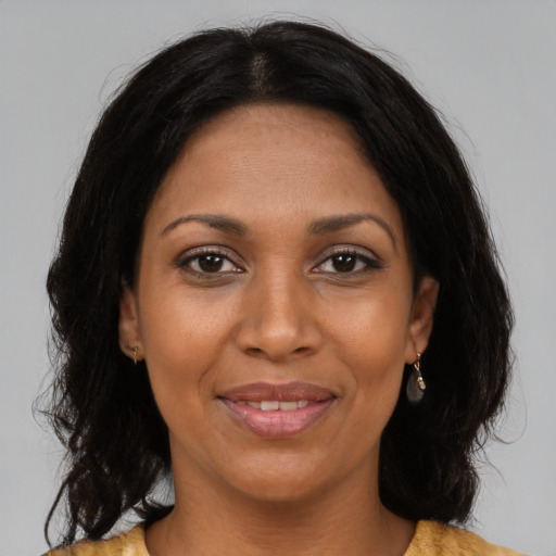Joyful black young-adult female with long  brown hair and brown eyes