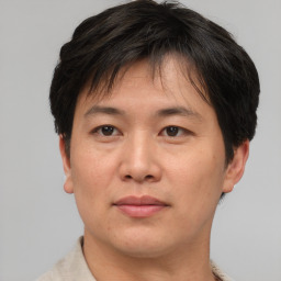 Joyful asian adult male with short  brown hair and brown eyes