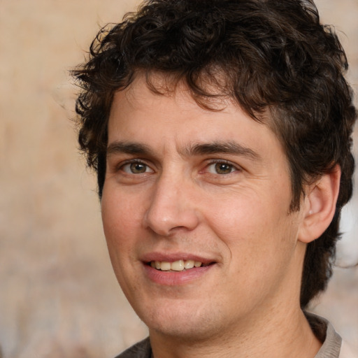 Joyful white young-adult male with medium  brown hair and brown eyes