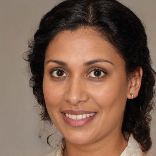 Joyful latino adult female with medium  brown hair and brown eyes
