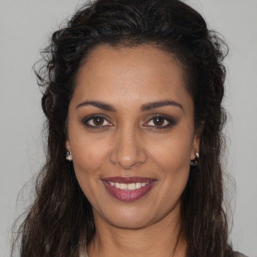 Joyful latino young-adult female with long  brown hair and brown eyes