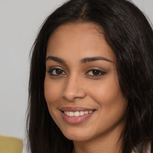 Joyful latino young-adult female with long  brown hair and brown eyes