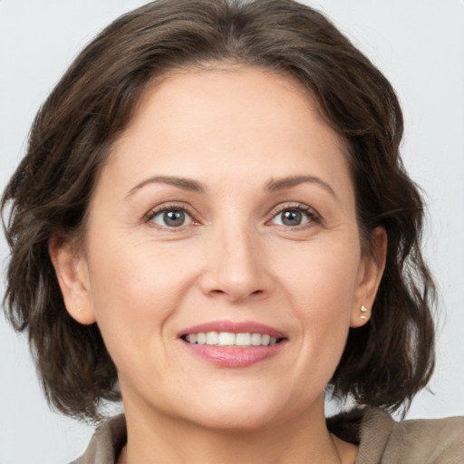 Joyful white adult female with medium  brown hair and grey eyes