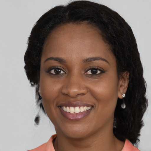 Joyful black young-adult female with medium  black hair and brown eyes