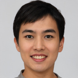 Joyful asian young-adult male with short  black hair and brown eyes