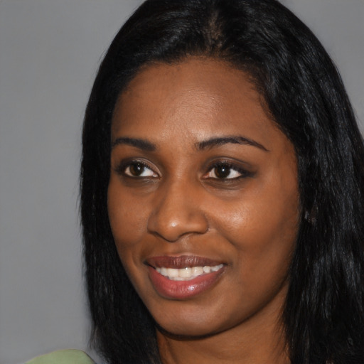 Joyful black young-adult female with long  black hair and brown eyes