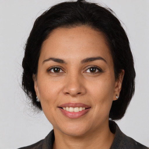 Joyful latino adult female with medium  brown hair and brown eyes