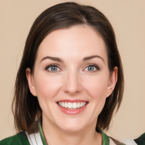 Joyful white young-adult female with medium  brown hair and green eyes