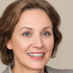 Joyful white adult female with medium  brown hair and green eyes