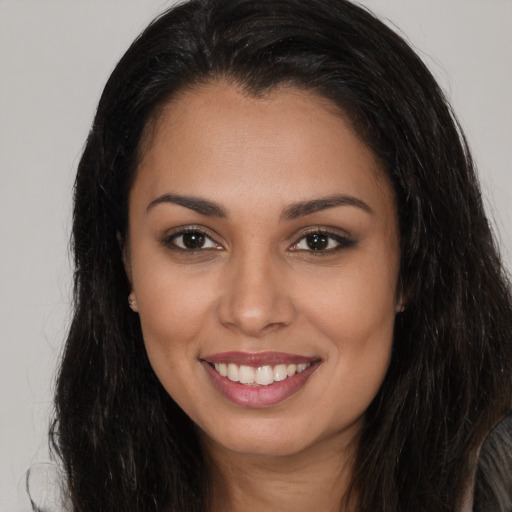 Joyful latino young-adult female with long  brown hair and brown eyes