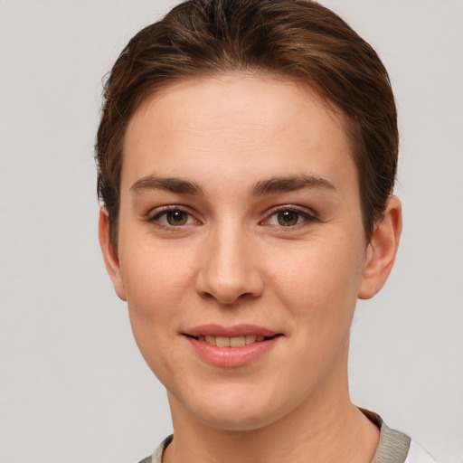 Joyful white young-adult female with short  brown hair and grey eyes