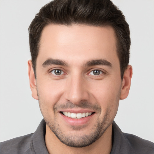 Joyful white young-adult male with short  brown hair and brown eyes